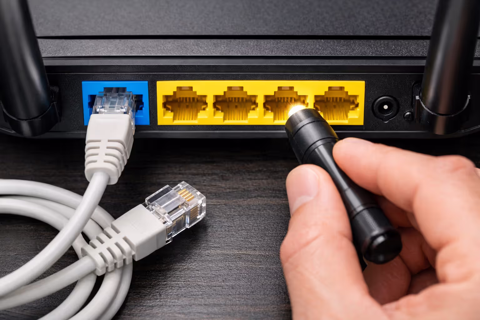 Close-up of a router front panel showing LED status indicators with WAN light glowing amber and power light glowing green